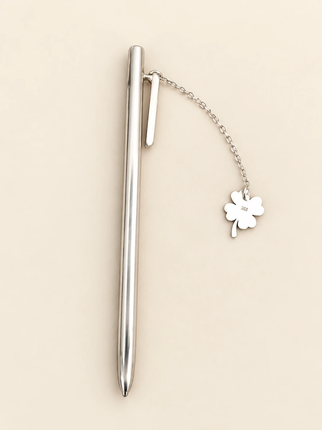 Smooth-bodied pen with a clip, linked chain and solid clover charm