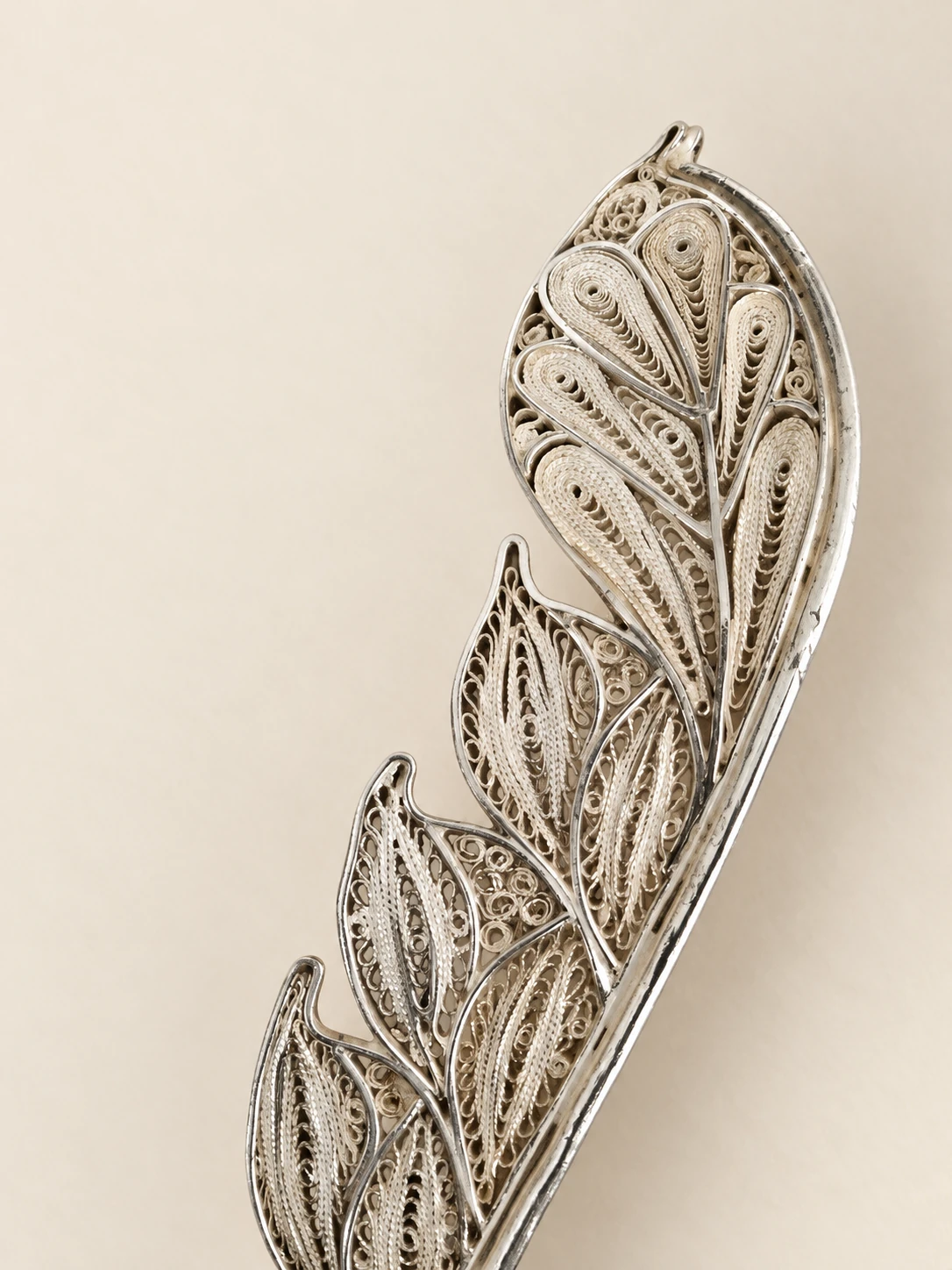 Front detail of the feather’s fine wires, spirals and openwork compartments