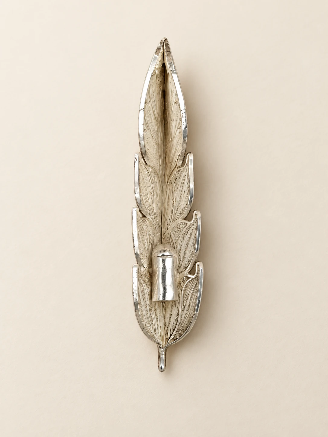 Reverse of the feather ornament showing the cylindrical pen attachment collar