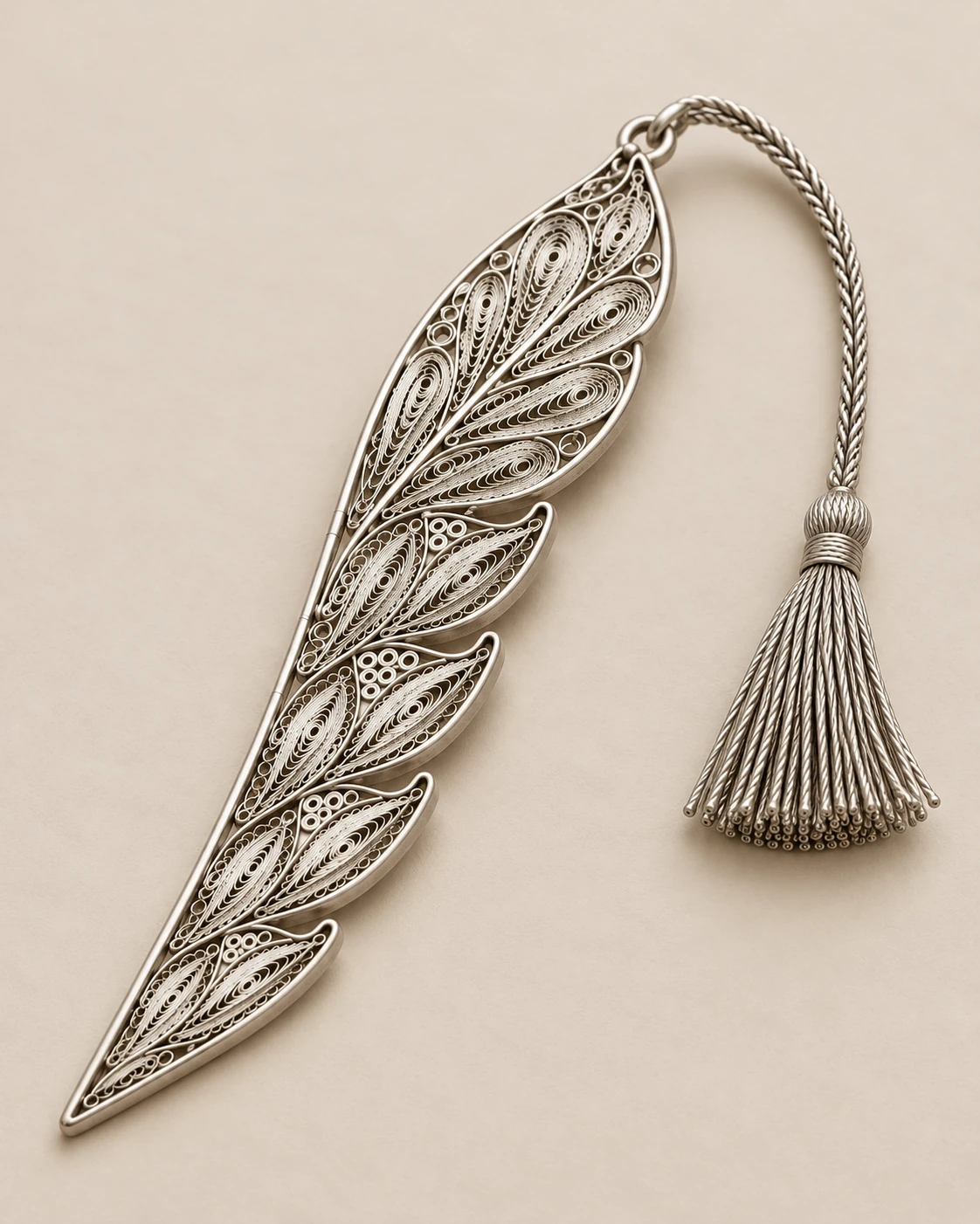 Proposed functional view of the filigree bookmark and tassel beside book pages