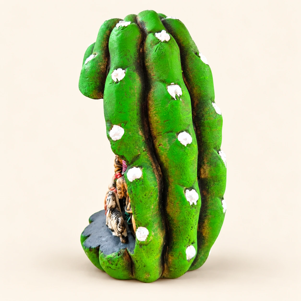 Green prickly pear pad with white flowers, a Nativity scene inside and an integrated base — side view